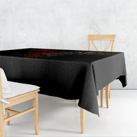 Black skull tablecloth draped over dining table edge, featuring red and gray skull artwork.