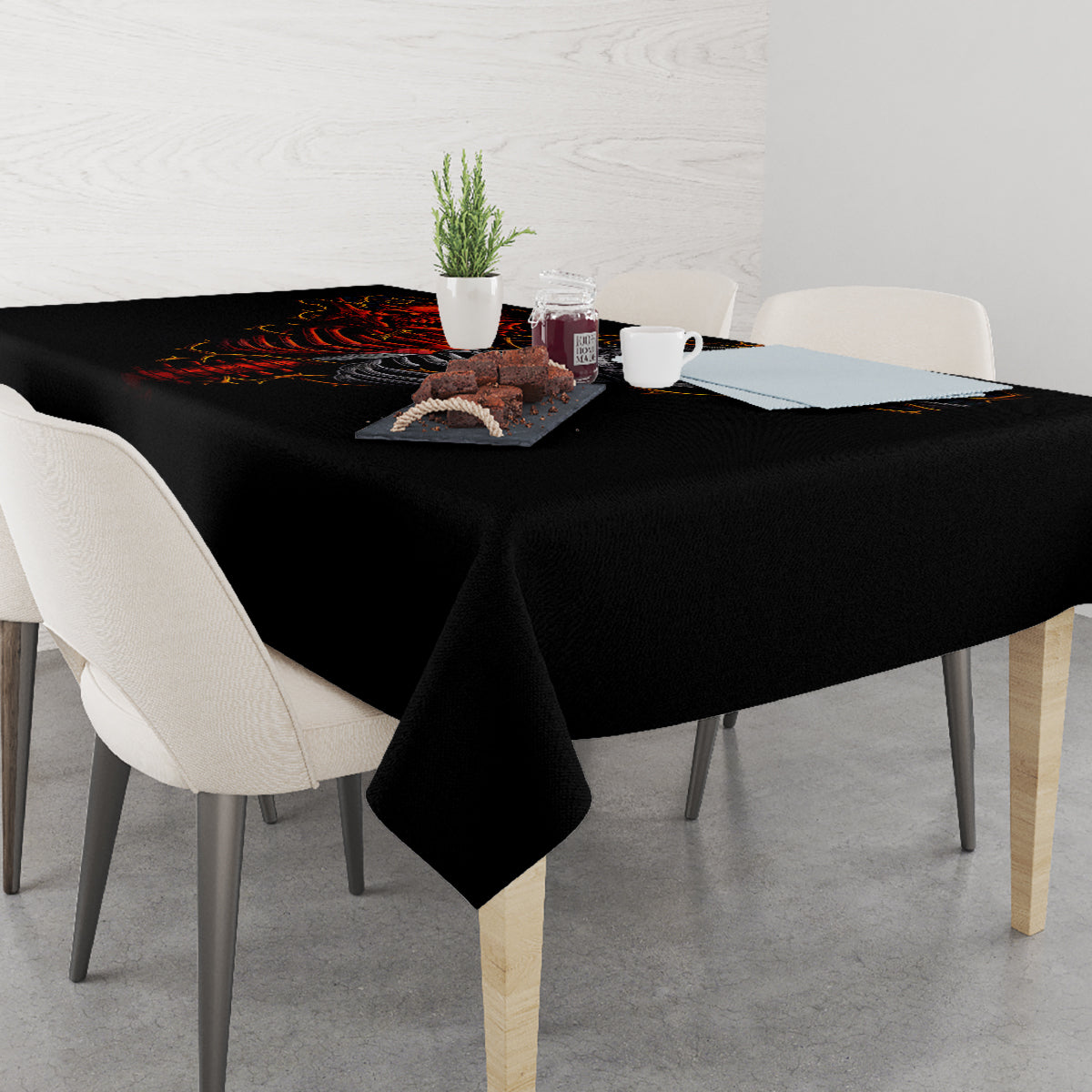 Black skull tablecloth covering a dining table, with flaming skeleton and skull design.