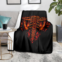 Black skull flame blanket folded on a couch, flaming skull face graphic