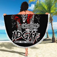 Black round beach blanket with skull graffiti design and white fringe edge, held up