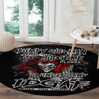 Black round rug with skull graphic and red/white text on a wooden floor