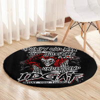 Black round area rug with skull graphic and red/white lettering on hardwood