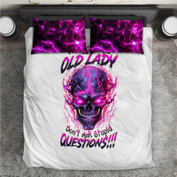 White comforter with purple skull face and text, plus two purple-patterned pillowcases