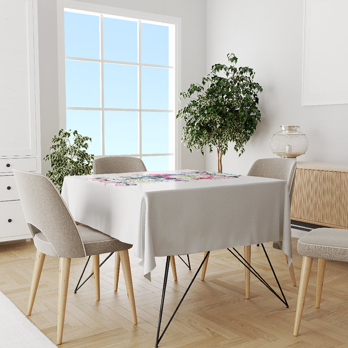 White tablecloth draped over a dining table with four chairs