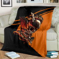 Black and orange skull with wings graphic blanket covering a couch