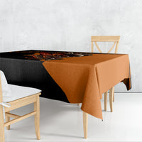 Black and orange skull tablecloth covering table, one corner hanging down