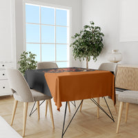 Black and orange skull tablecloth on dining table with multiple chairs