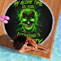 Black round beach blanket with neon green skull graphic and white fringe border.