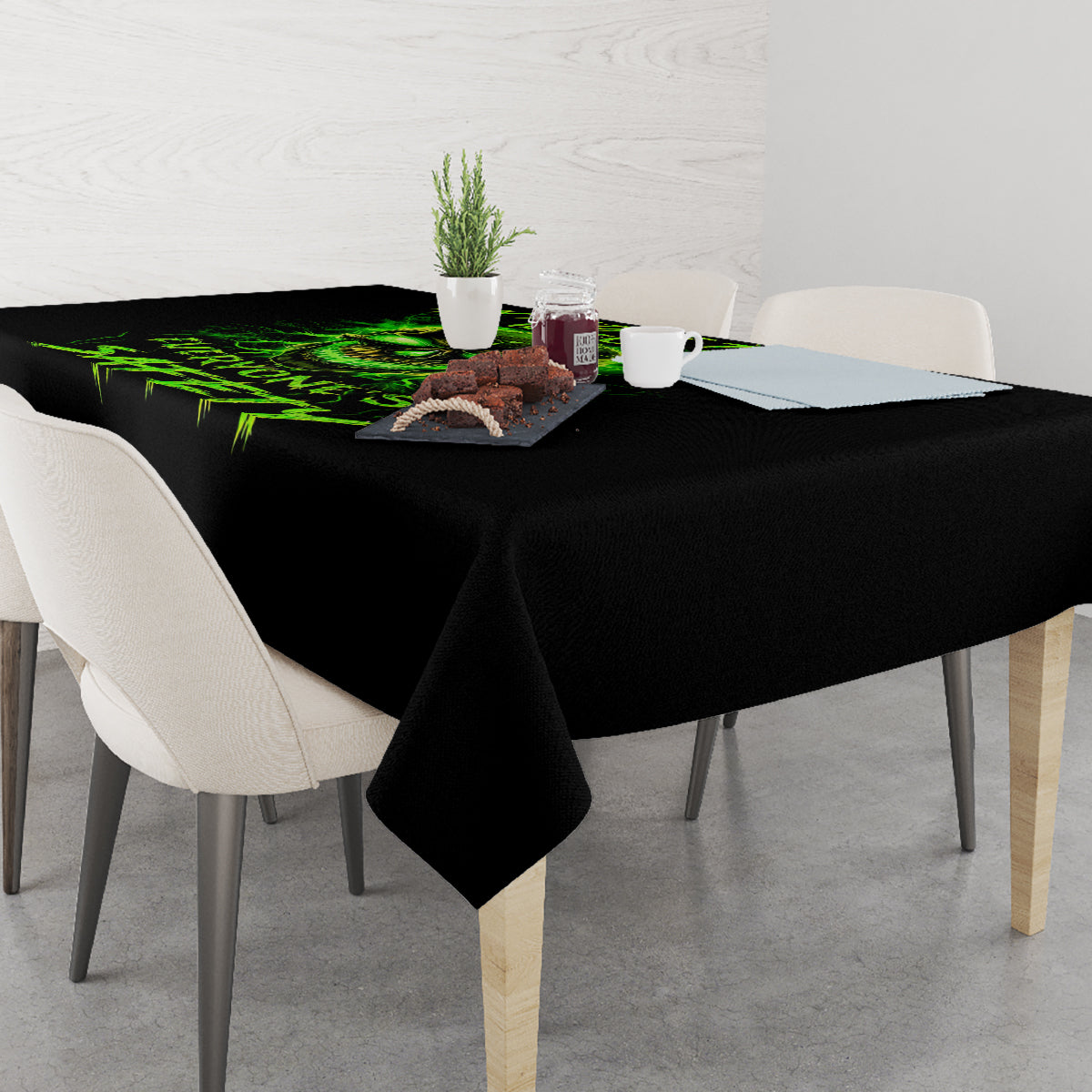 Black tablecloth on dining table with neon green flame skull graphic across the top.