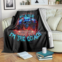 Black skull graphic blanket draped over couch, PLAYer and coach text in color