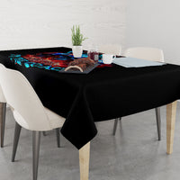 Black skull tablecloth draped on dining table with colorful skull print.