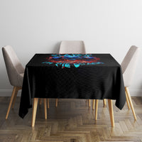 Black skull tablecloth covering dining table with colorful skull graphic center.
