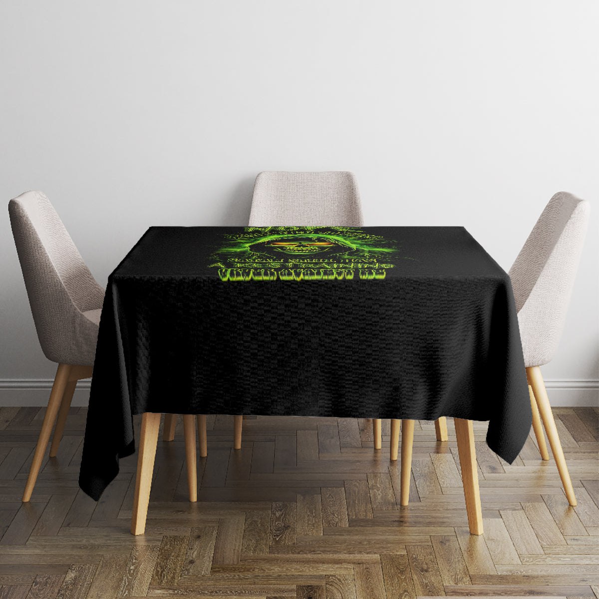 Black tablecloth with green skull graphic on square dining table with two upholstered chairs.