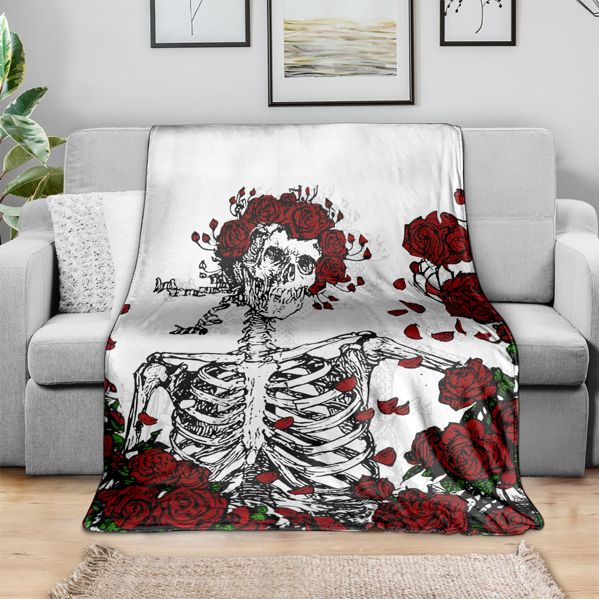 White blanket with red roses and skull skeleton graphic draped over sofa