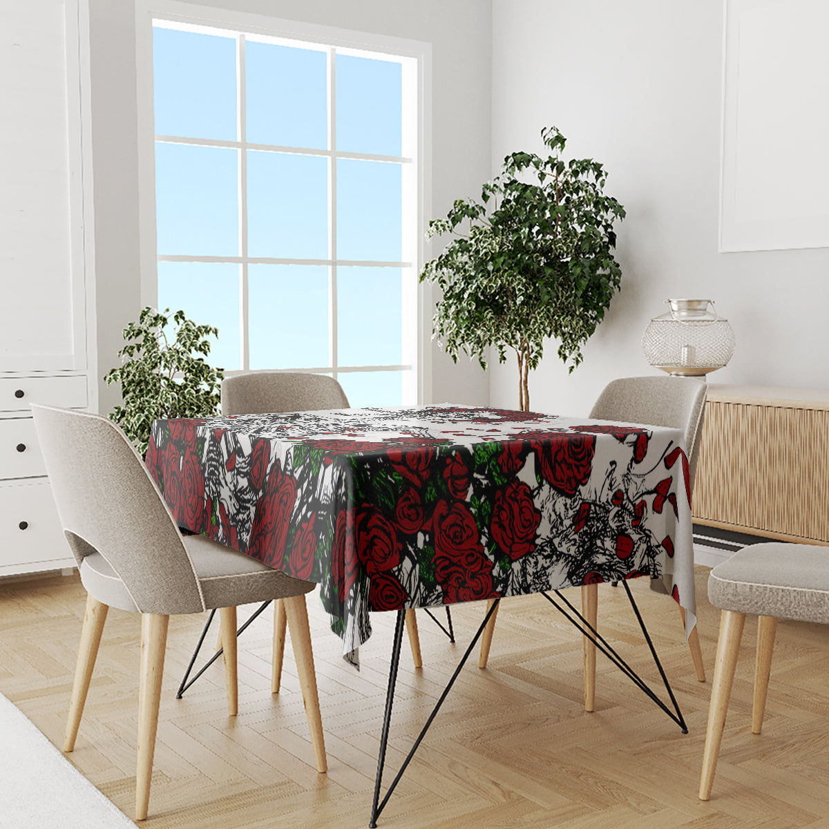 Skull and rose print tablecloth covering dining table, red roses and black motifs