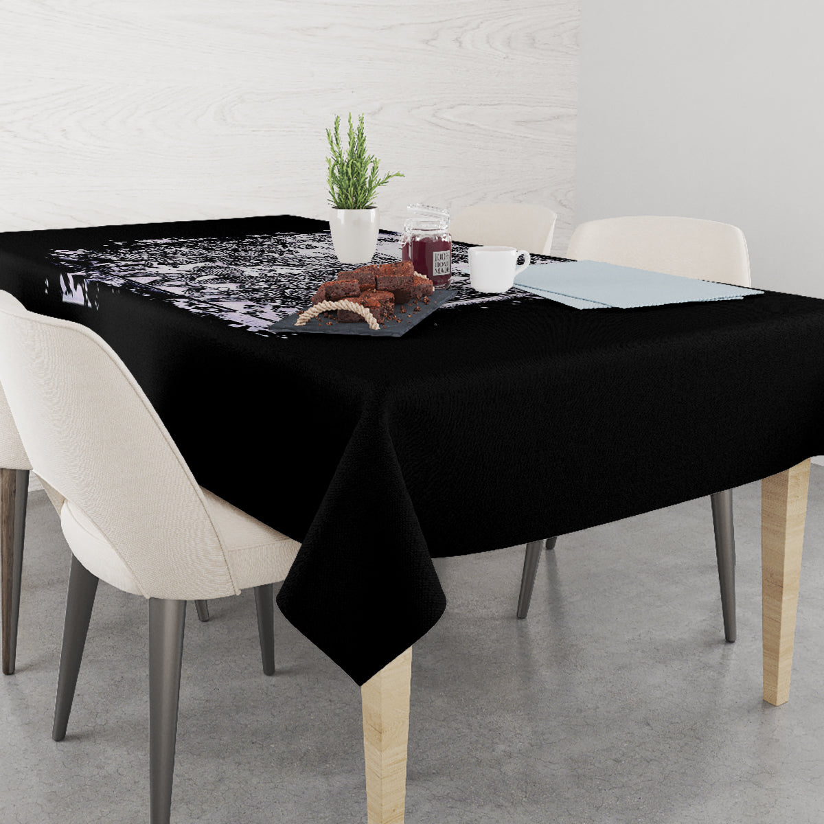 Black tablecloth with white skull-and-rose design on table corner