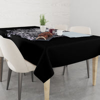 Black tablecloth with white skull-and-rose design on table corner