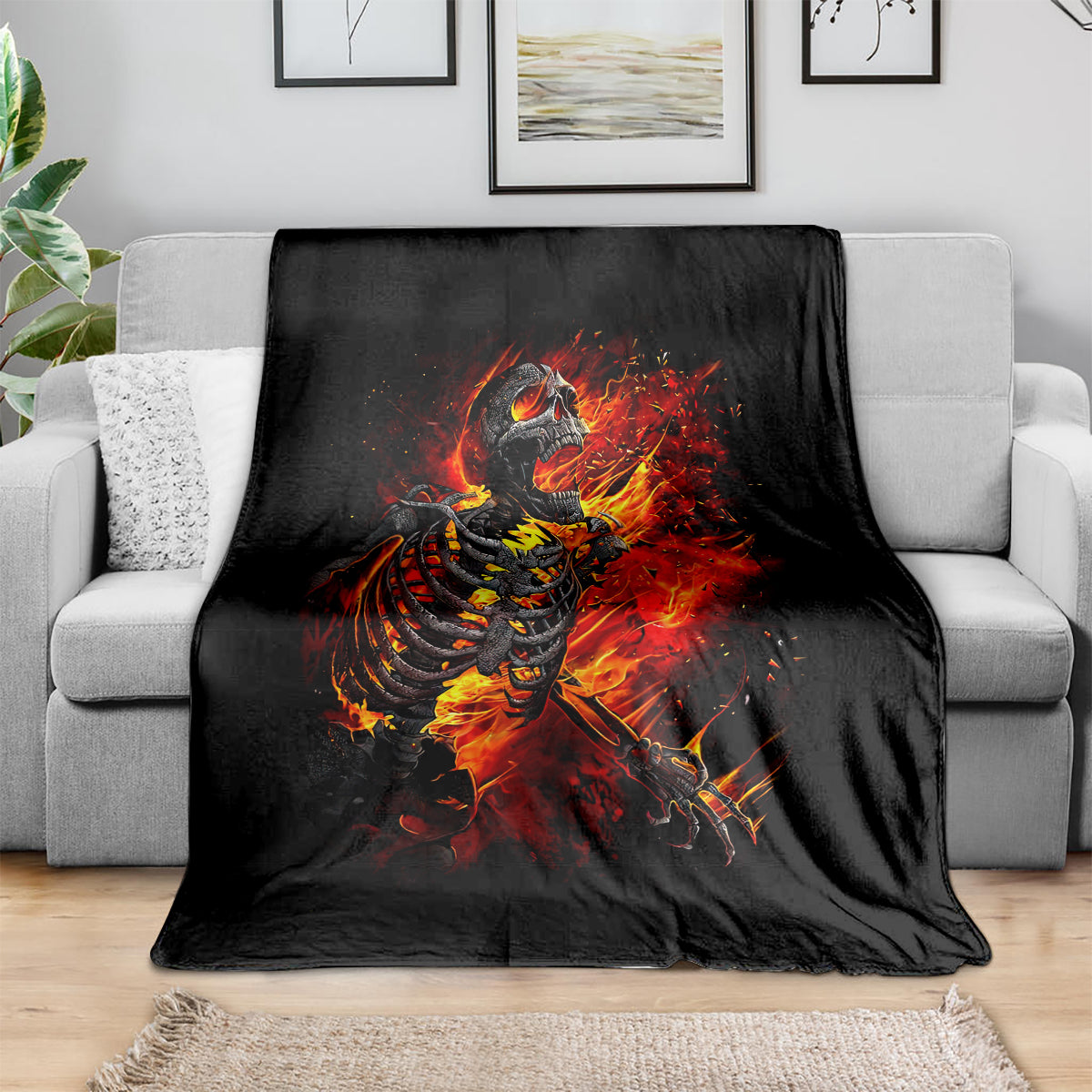 Black fire skull skeleton blanket draped over gray sofa
