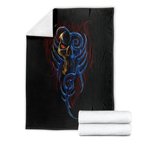 Black devil skull blanket with blue devil face print, shown with folded white towels