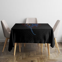 Black tablecloth with blue spiral devil face graphic on square table with chairs