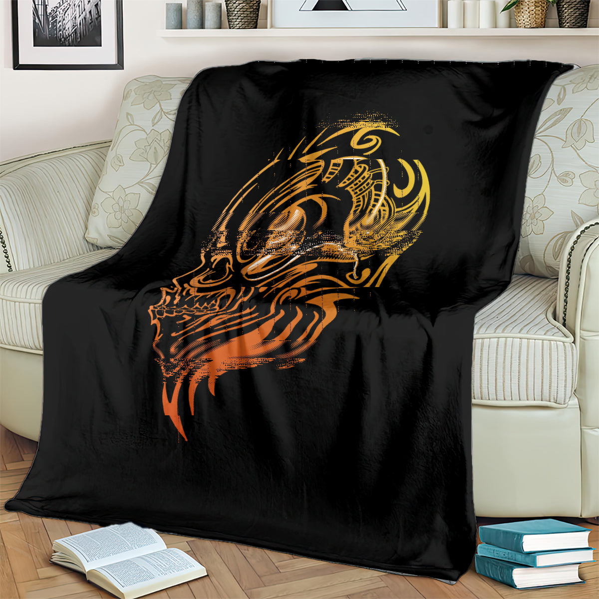Black tattoo skull blanket with golden head graphic and orange accents, on couch