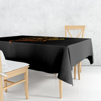 Black tablecloth draped over table edge, featuring golden skull face tattoo design