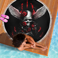 Black round beach blanket featuring skull with gray wings, red roses, and white fringe.