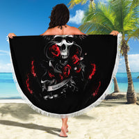 Black round beach blanket with skull and gray wings, red roses, and white tassel fringe.