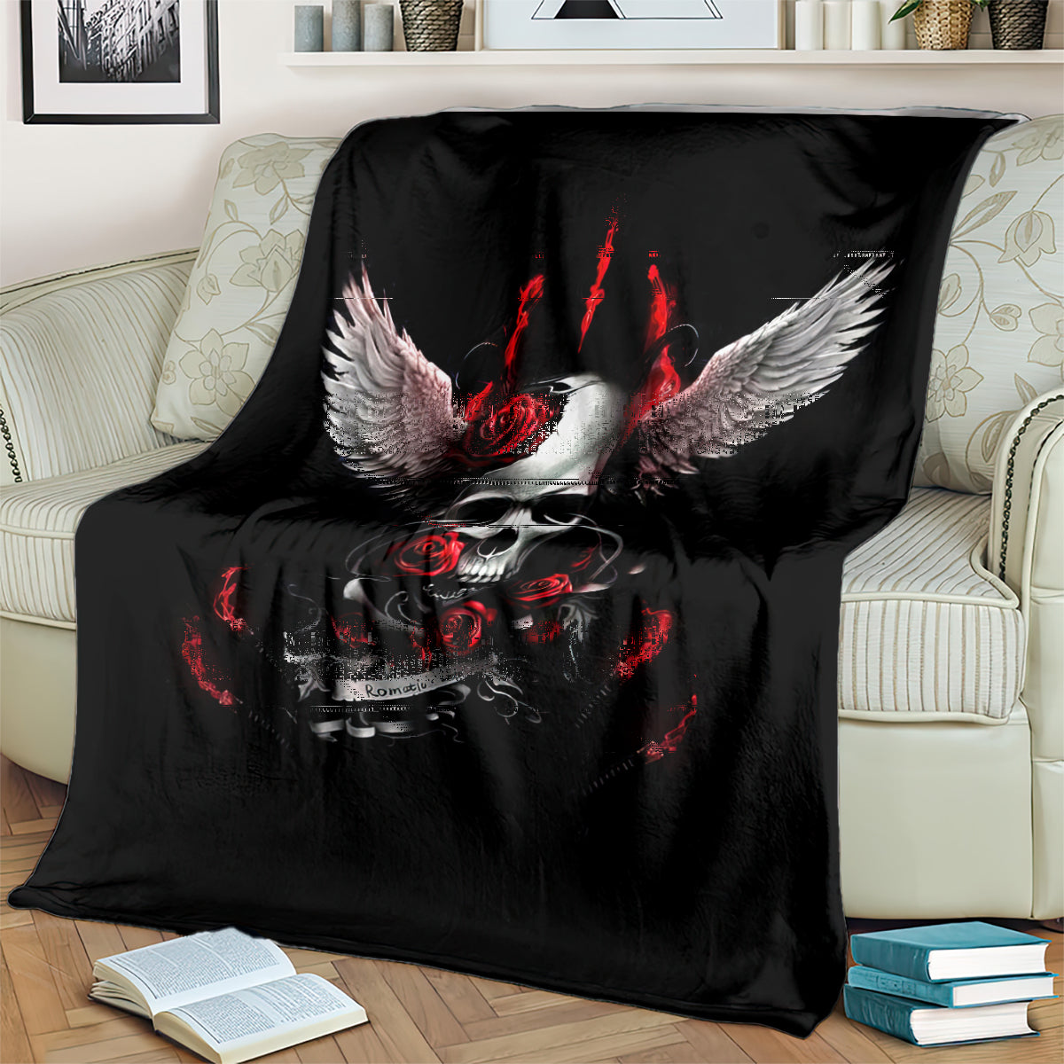 Black skull wings throw blanket with red roses and flame details, on a couch