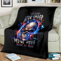 Black throw blanket on couch with fiery blue-red skull graphic and flame accents