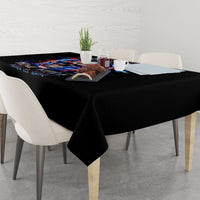 Black tablecloth with colorful skull-and-flame artwork draping over dining table