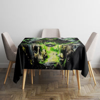 Black tablecloth with green graveyard skull scene, draped over dining table