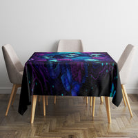 Black tablecloth on square dining table with purple-blue skull and rose pattern.