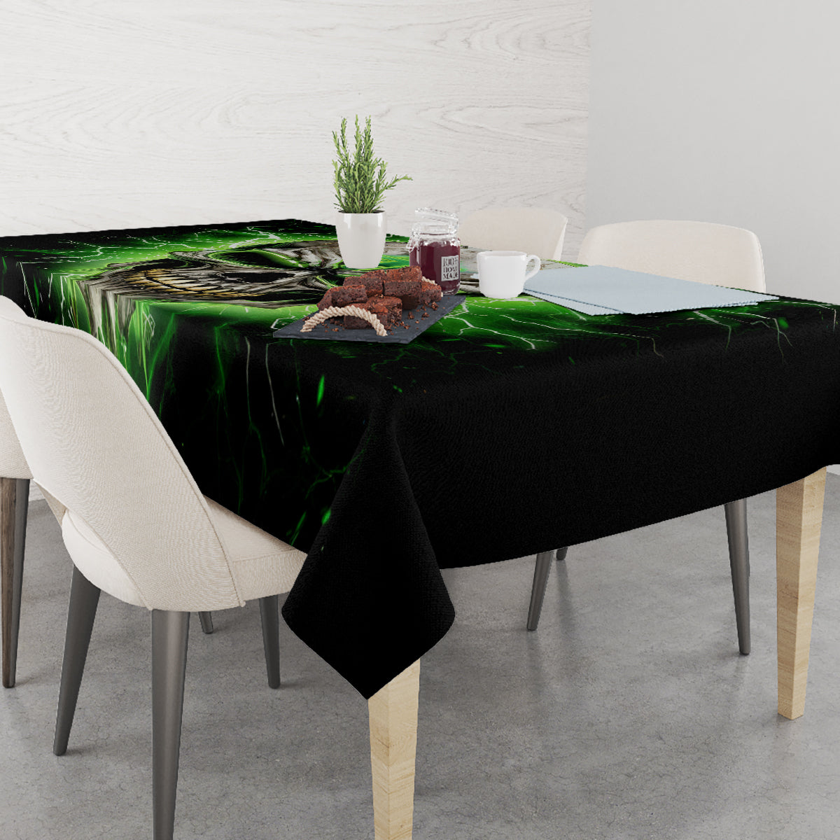 Black tablecloth on dining table with green lightning skull artwork and items