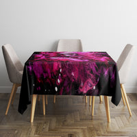 Black tablecloth with purple skull-lady splash graphic on rectangular table, hem visible