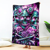 Purple skull and rose blanket with teal accents, folded and standing upright
