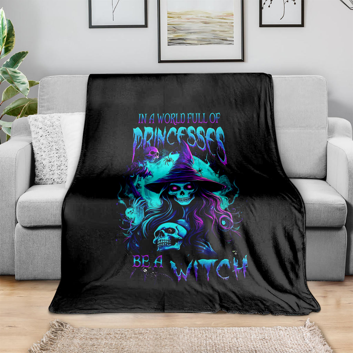 Black witch skull throw blanket with neon purple and blue graphic, draped on sofa