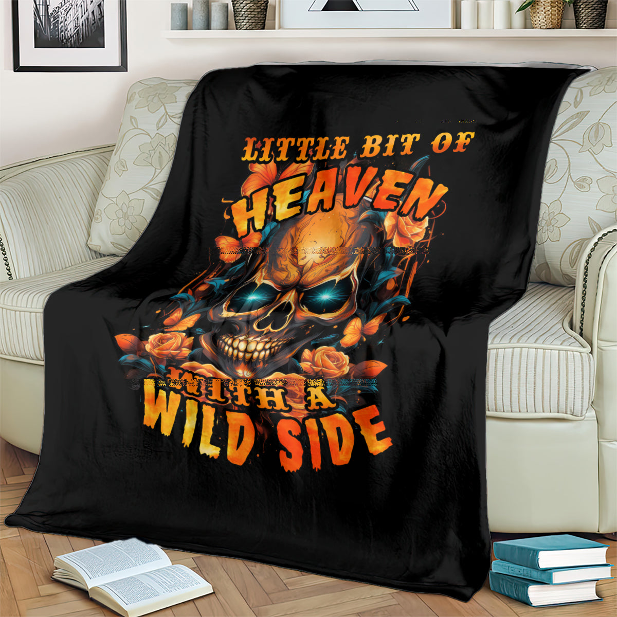 Black throw blanket with flaming skull and roses artwork, draped on sofa