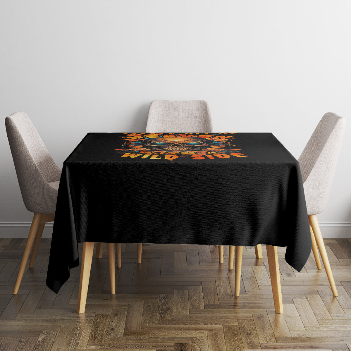 Black square tablecloth with orange skull and floral design on dining table