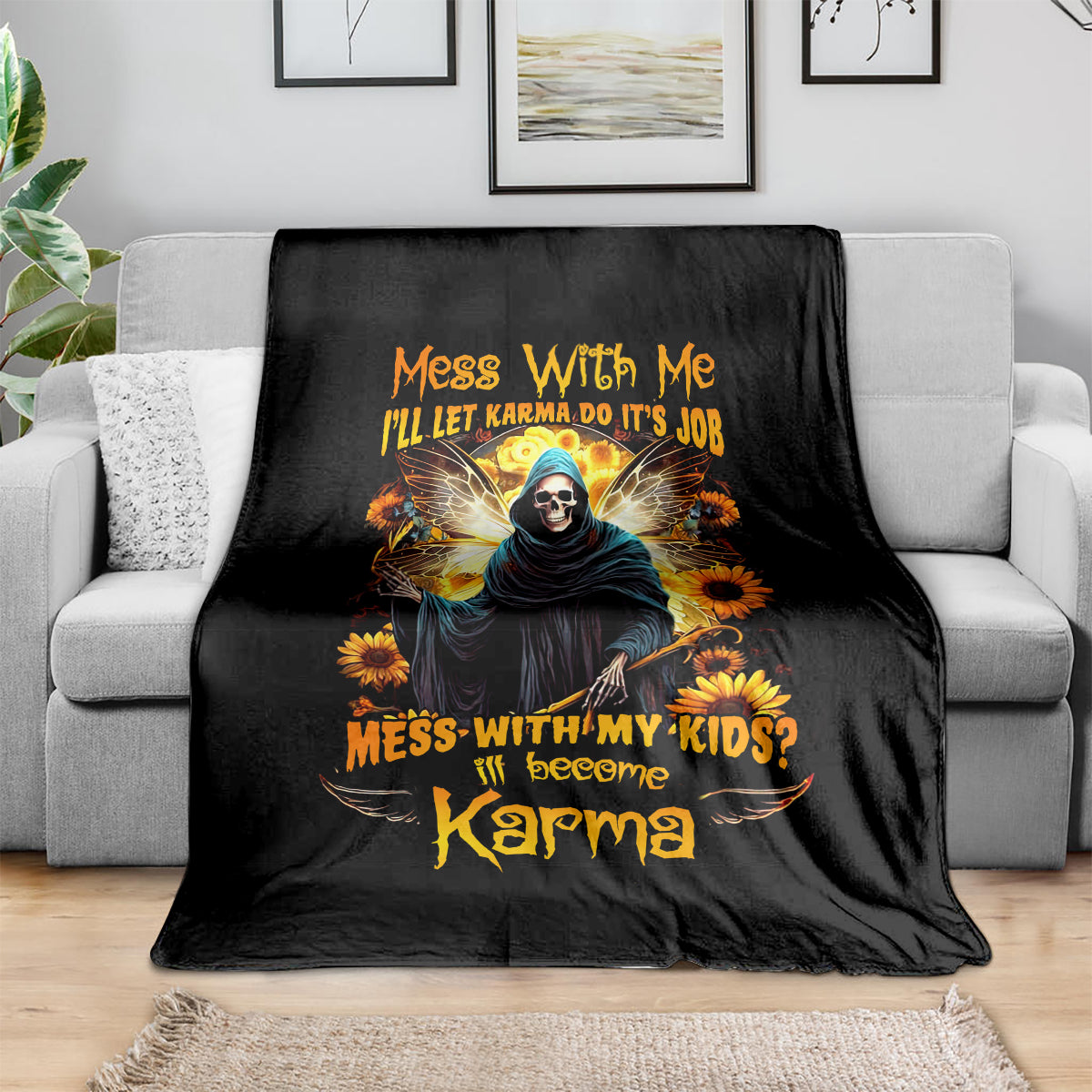 Black skull and hooded figure graphic blanket with sunflowers and bold orange lettering