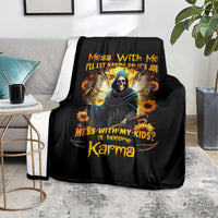 Black hooded skull graphic blanket on couch, sunflower accents and orange text