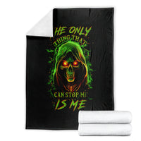 Black skull graphic throw blanket with green flaming skull face art, folded with white towels