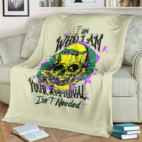 Light green blanket draped on a sofa showing a colorful skull and purple splashes