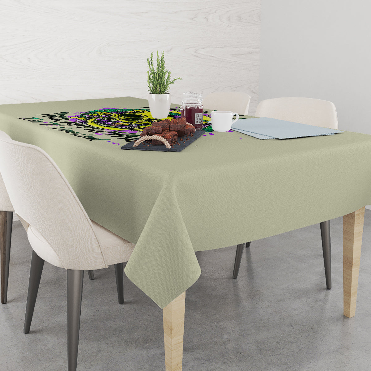 Green tablecloth on dining table with colorful skull-and-flower print near center