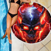 Round beach blanket with flaming skull graphic and white fringed edge near pool