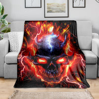 Black flame skull graphic blanket spread across a gray sofa