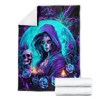 Folded witch skull blanket with teal hooded sorceress, roses, skull, and candle flames