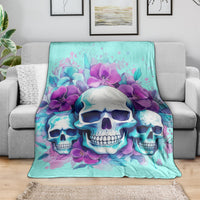 Turquoise skull and purple flower blanket on a gray couch, fully spread
