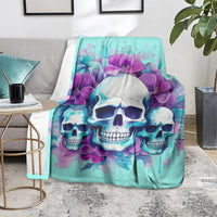 Turquoise skull floral blanket on a rug beside a gray couch and side tables