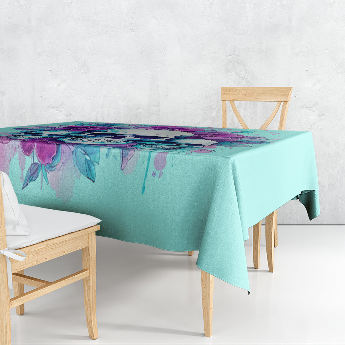 Blue rectangular tablecloth draped on dining table with colorful floral skull design